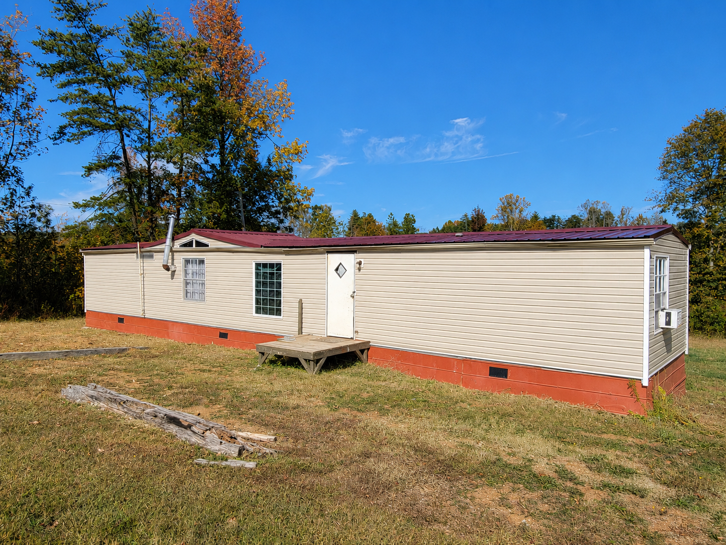 Exterior of 161 Hickory Grove Church Road, a singlewide manufactured home with tan siding and a red metal roof at 161 Hickory Grove Church Road