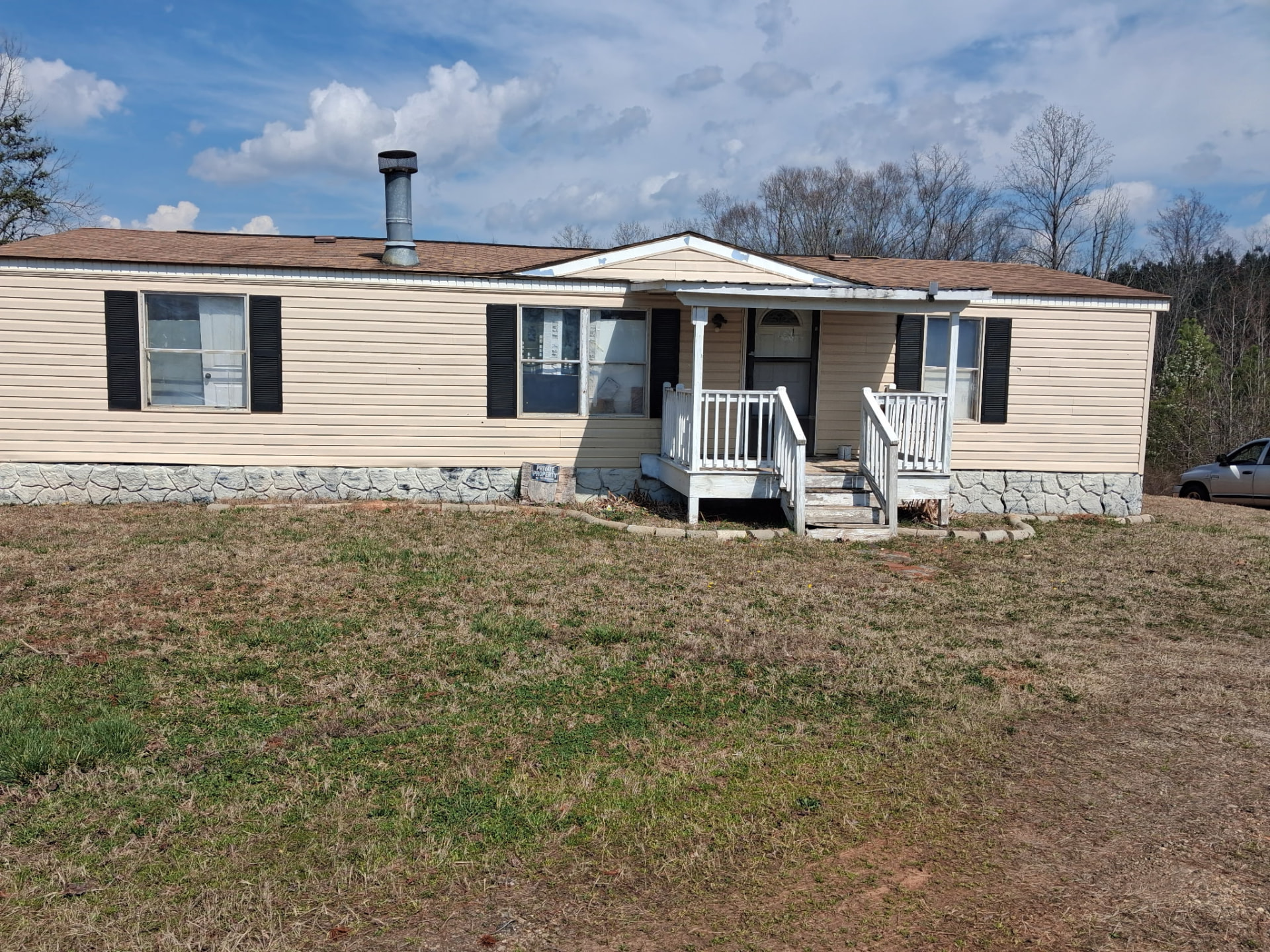 Front exterior of 159 Hickory Grove Church Road, a doublewide manufactured home with tan siding and a covered front entry at 159 Hickory Grove Church Road